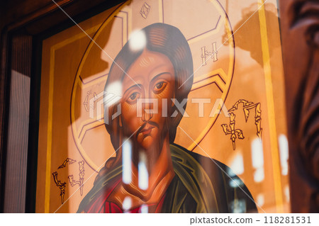 Light reflections on a detailed Christ icon in a serene setting 118281531