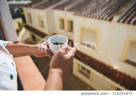 A serene morning moment holding a cup of coffee on a balcony overlooking charming Mediterranean rooftops 118281671