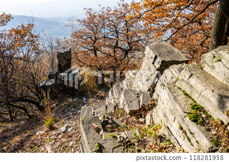 Visitors can wander along the ancient rocky trail of Sedlo Mountain, surrounded by vibrant autumn foliage on a sunny day in the Central Bohemian Uplands of Czechia. 118281958