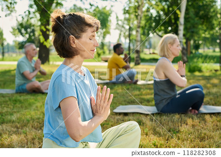 Mature serene woman doing yoga exercise Mature serene woman doing yoga exercise 118282308
