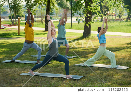 People exercising on mats on green lawn People exercising on mats on green lawn 118282333