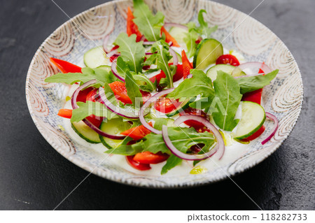 Colorful fresh salad with arugula, cucumbers, and tomatoes - a perfect dish for healthy eating Colorful fresh salad with arugula, cucumbers, and tomatoes - a perfect dish for healthy eating 118282733