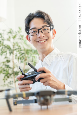 A young man operating a drone 118283258