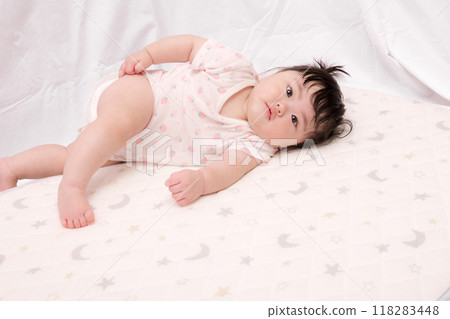 [Lying down baby with tied hair] 118283448