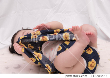 [Lying down baby with tied hair] 118283455