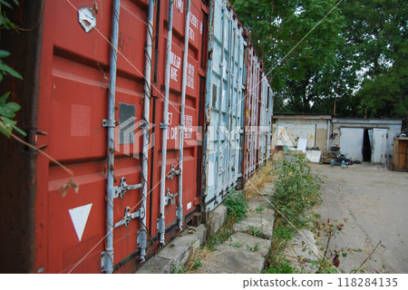 Twenty foot sea containers. The containers are placed in a row and are used for storage. 118284135