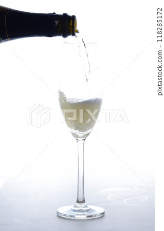 Pour champagne (sparkling wine) into a flute glass 118285172