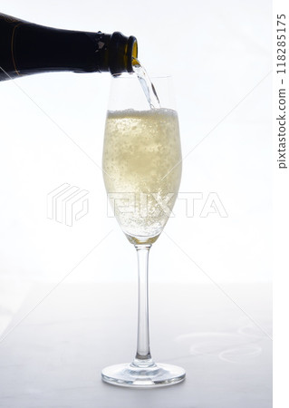 Pour champagne (sparkling wine) into a flute glass Pour champagne (sparkling wine) into a flute glass 118285175