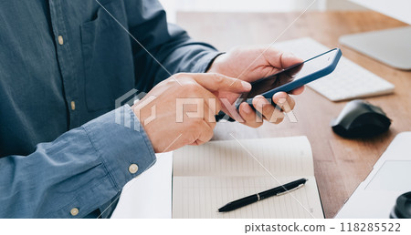 Hand of a man manipulating a smartphone 118285522