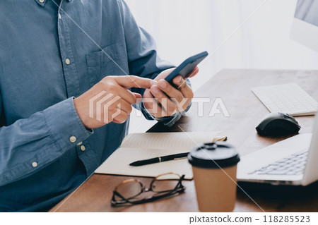 Hand of a man manipulating a smartphone Hand of a man manipulating a smartphone 118285523