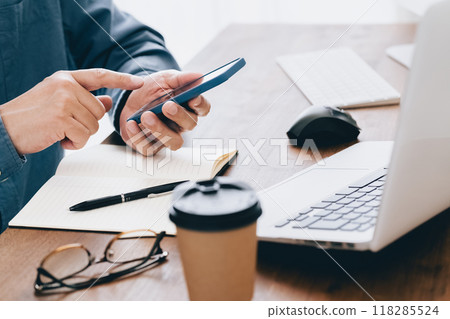Hand of a man manipulating a smartphone 118285524