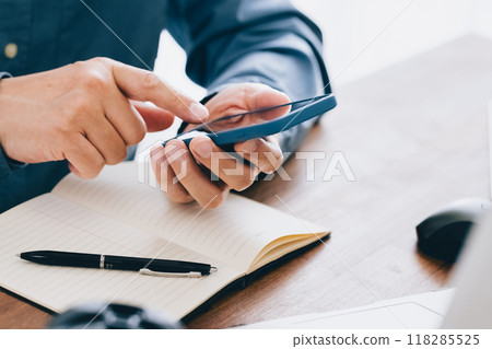 Hand of a man manipulating a smartphone 118285525