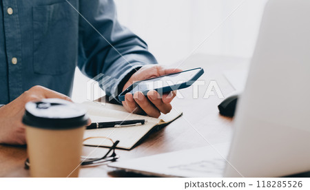 Hand of a man manipulating a smartphone 118285526