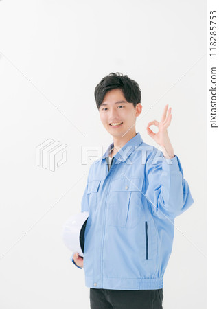 一個穿著工作服的男人用手指說“好” 118285753
