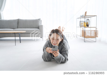Woman relaxing in the living room Woman relaxing in the living room 118286993