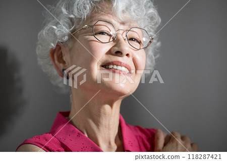 Close-up of a gray-haired elderly (senior) woman looking up. Skin care, hair care, beauty image. Beautiful 118287421