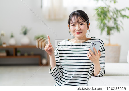 A young woman using a smartphone. A young woman using a smartphone. 118287629