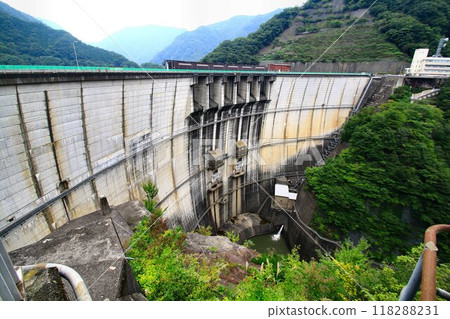 A beautiful curved arch dam… “Kawaji Dam” filled with water in the middle of nature 118288231