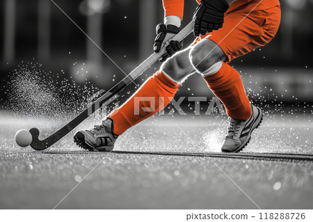 Dynamic hockey player executing a powerful shot on a vibrant field during a competitive match showcasing skill and precision 118288726
