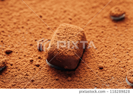 Close-up of chocolate truffle covered in cocoa powder, creating a rich and textured dessert scene Close-up of chocolate truffle covered in cocoa powder, creating a rich and textured dessert scene 118289828