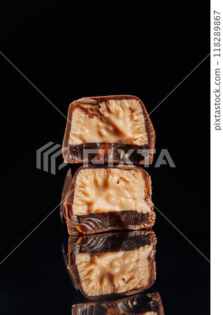 Decadent chocolate candy with gooey caramel filling, perfect for confectionery and dessert themes Decadent chocolate candy with gooey caramel filling, perfect for confectionery and dessert themes 118289867