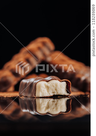 Chocolate bar with creamy filling on dark background, ideal for dessert and confectionery concepts 118289869