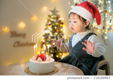 Christmas: 1-year-old child gazing at candles on cake Christmas: 1-year-old child gazing at candles on cake 118289907