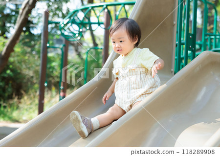 One-year-old child playing on the slide One-year-old child playing on the slide 118289908