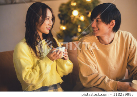 A young couple relaxing in a room decorated with a Christmas tree 118289993