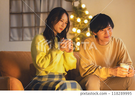 A young couple relaxing in a room decorated with a Christmas tree 118289995
