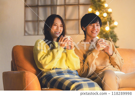 A young couple relaxing in a room decorated with a Christmas tree 118289998