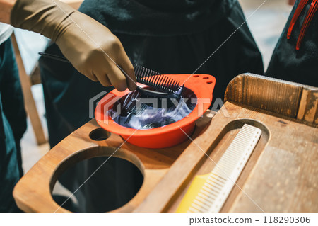 Hairdresser's hands applying color to a hair color brush Hairdresser's hands applying color to a hair color brush 118290306