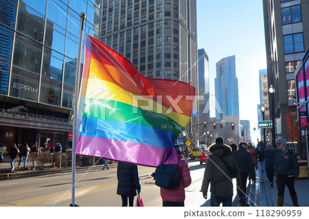 A LGBTQ flag waves  against a city street backdrop 118290959