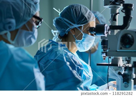 Scientists in lab coats and masks conducting research with a modern microscope in a laboratory,  advanced medical research practices 118291282