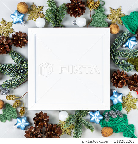 Creative Christmas composition with a white frame for text and congratulations on the New Year and Christmas. Christmas tree branches, decorative ornaments 118292203