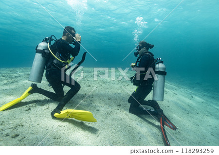 Diving instructor trains a novice who is learning to dive , underwater , Red sea . 118293259