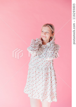 Beautiful woman in summer dress holding her hair with her hands Beautiful woman in summer dress holding her hair with her hands 118293803