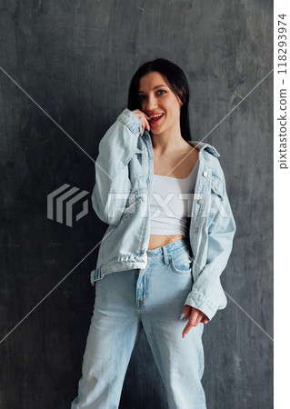 Beautiful fashionable brunette woman in denim suit smiling Beautiful fashionable brunette woman in denim suit smiling 118293974