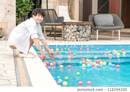 Young Asian man playing by the pool at a vacation resort 118294200
