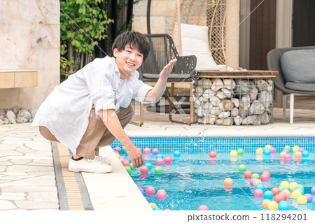 Young Asian man playing by the pool at a vacation resort 118294201