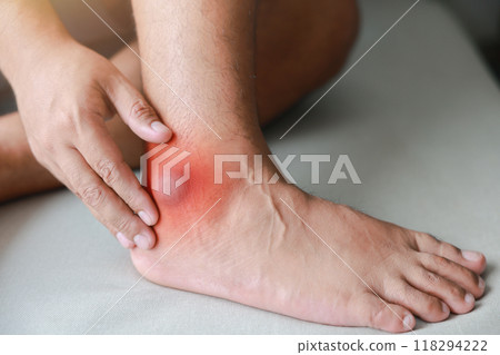 A man injured his ankle and it was swollen and red. Causes of pain include Ankle sprain, Gout, Rheumatoid arthritis, office syndrome, numbness, and cramp symptoms. Healthcare medical concept. A man injured his ankle and it was swollen and red. Causes of pain include Ankle sprain, Gout, Rheumatoid arthritis, office syndrome, numbness, and cramp symptoms. Healthcare medical concept. 118294222