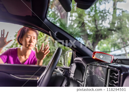 Senior asian woman forgot her key inside locked car. Senior asian woman forgot her key inside locked car. 118294501