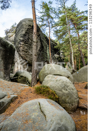 The picturesque landscape at Besedice Rocks showcases vibrant autumn colors with mossy boulders, towering trees, and unique rock formations, creating a serene natural environment. 118296349