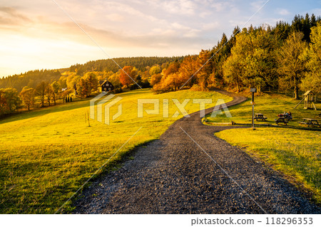 Autumn hilly landscape with country road at sunset time. Colorful trees and meadows around Cottage U Samalu, Prosec pod Jestedem, Czech Republic Autumn hilly landscape with country road at sunset time. Colorful trees and meadows around Cottage U Samalu, Prosec pod Jestedem, Czech Republic 118296353