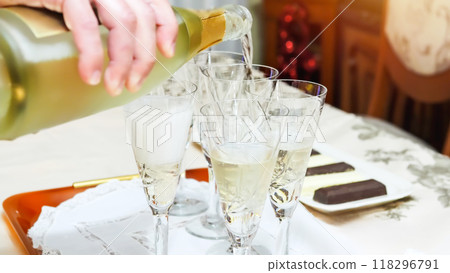 Pouring Champagne into Glasses for Celebration Pouring Champagne into Glasses for Celebration 118296791