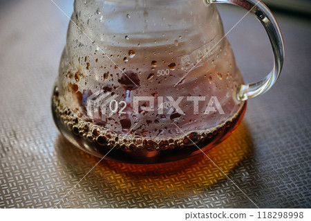 Coffee poured into a glass server Coffee poured into a glass server 118298998
