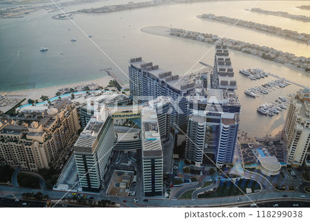 Aerial view of modern luxury buildings near the waterfront in Dubai during sunset, showcasing the marina and surrounding landscape Aerial view of modern luxury buildings near the waterfront in Dubai during sunset, showcasing the marina and surrounding landscape 118299038