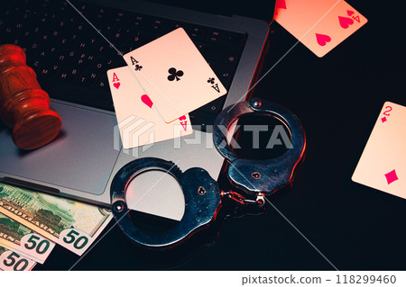 A Gavel, Handcuffs, Playing Cards, and Cash on a Laptop. A Gavel, Handcuffs, Playing Cards, and Cash on a Laptop. 118299460