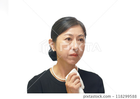 A middle-aged woman wearing mourning clothes wiping away tears with a white handkerchief A middle-aged woman wearing mourning clothes wiping away tears with a white handkerchief 118299588