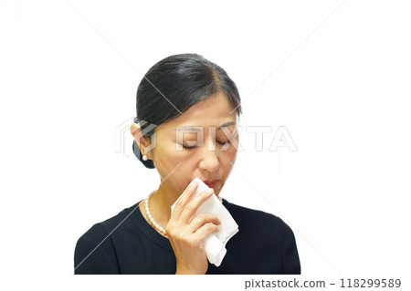 A middle-aged woman wearing mourning clothes wiping away tears with a white handkerchief A middle-aged woman wearing mourning clothes wiping away tears with a white handkerchief 118299589